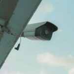 pexels photo 18124167 18124167 2 A security camera mounted on a building eaves under a clear blue sky.