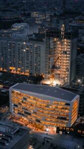 Dramatic aerial view of Lyon's brightly lit modern buildings against the night sky.